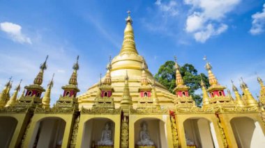 Tayland tapınağında gündüz vakti bulutlu gökyüzünün altında altın pagoda.