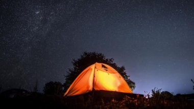 Samanyolu ve gecenin yıldızları, Tayland 'da kamp çadırıyla dağın tepesinde berrak bir gökyüzü.