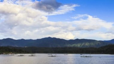Sabah vakti güneş doğarken ve bulutluyken göldeki suyun üzerindeki dağ yansıması.