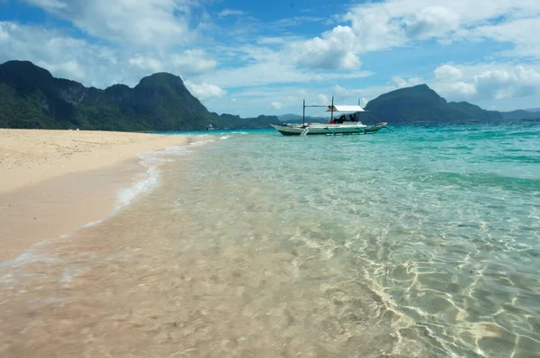 Filipinler 'deki kumlu sahilde deniz kayalıklarına karşı turist teknesi