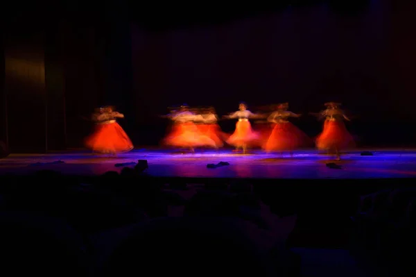 黒の背景にステージで踊る人々 のグループ — ストック写真