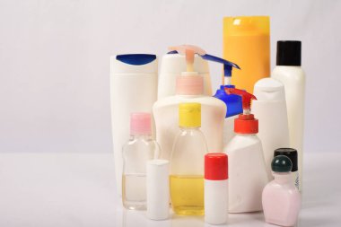 Beyaz arka plan üzerinde birçok beyaz plastik şişe. 