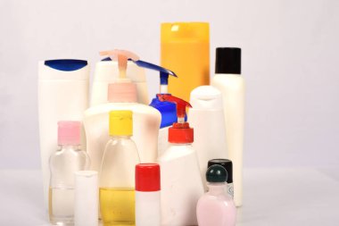 Beyaz arka plan üzerinde birçok beyaz plastik şişe. 