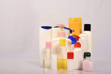 Beyaz arka plan üzerinde birçok beyaz plastik şişe. 