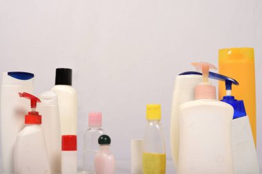 Beyaz arka plan üzerinde birçok beyaz plastik şişe. 