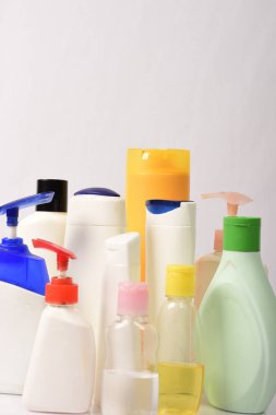 Beyaz arka plan üzerinde birçok beyaz plastik şişe. 