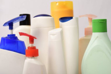 Beyaz arka plan üzerinde birçok beyaz plastik şişe. 