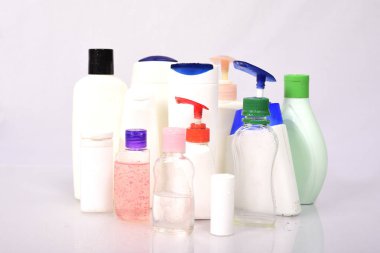 Beyaz arka plan üzerinde birçok beyaz plastik şişe. 