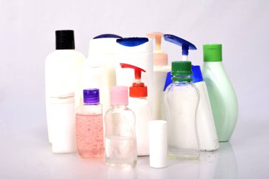 Beyaz arka plan üzerinde birçok beyaz plastik şişe. 