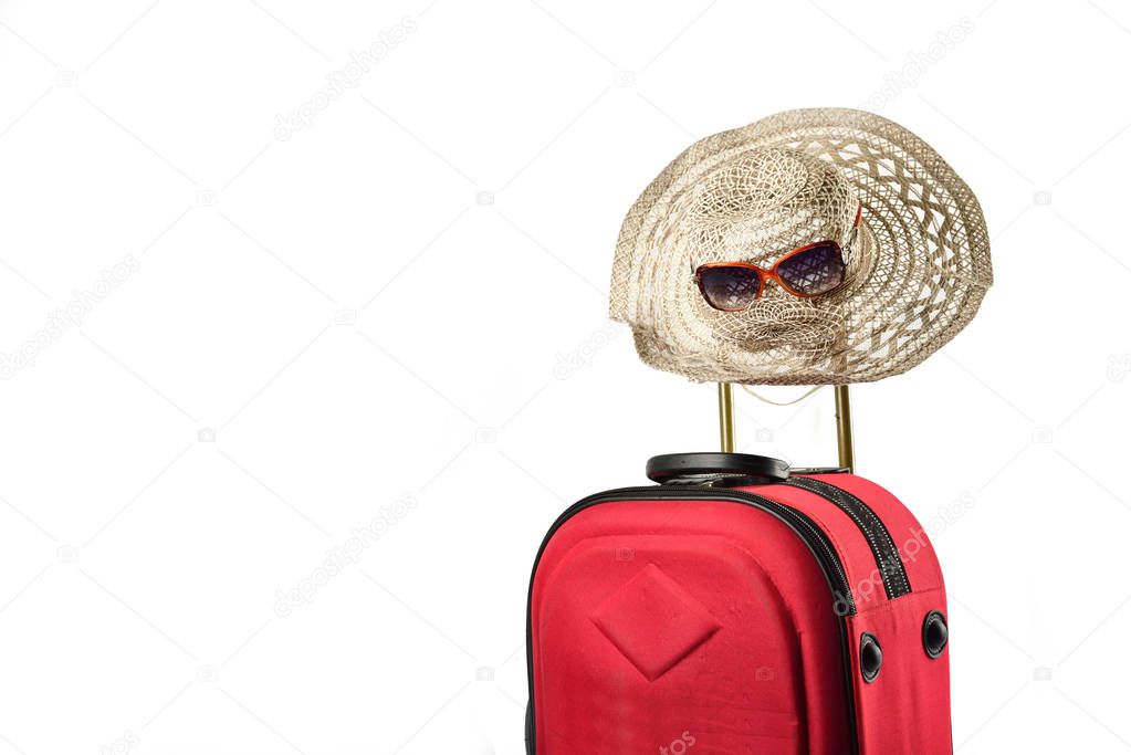 Suitcase and summer hat isolated on white background