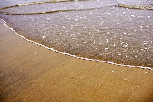 空の海のビーチで水の縁のクローズ アップ — ストック写真