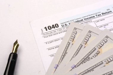 Beyaz arka plan üzerinde 1040 Abd vergi iadesi formu tamamlanması. 