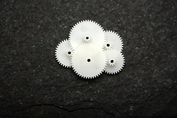 Beyaz tekerlek dişlileri siyah doku arka planında