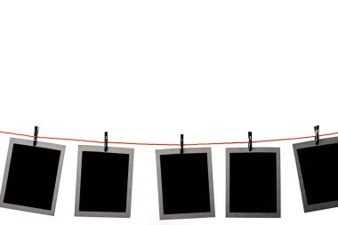 Beyaz arka planda bir satırda asılı Boş Polaroid resimler