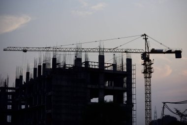 Gün batımında vinçli inşaat binası