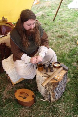 Battle, UK - 12 Ekim 2019: Hastings Muharebesi sırasında Sakson kampından bir sahneyi yeniden canlandıran aktör. Bu durumda bir adam çekiçle para kazanıyor..