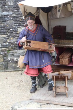 Battle, UK - 12 Ekim 2019: Hastings Muharebesi sırasında Sakson kampından bir sahneyi yeniden canlandıran aktör. Bu durumda bir adam ortaçağ enstrümanı çalıyor..