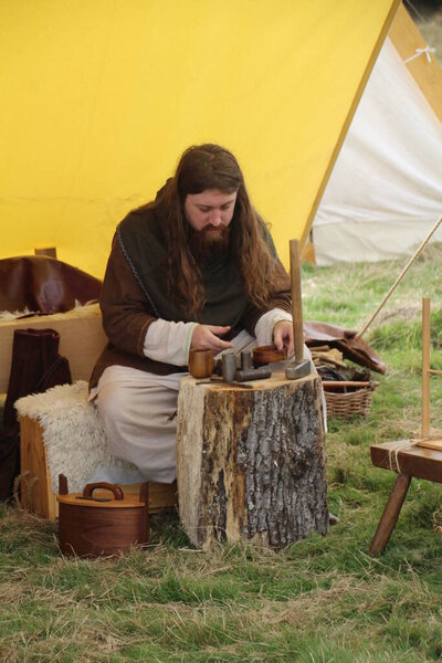 Battle, UK - 12 October, 2019: Re-enactor recreating a scene from a Saxon encampment around the time of the battle of Hastings. In this case a man making hammered coins