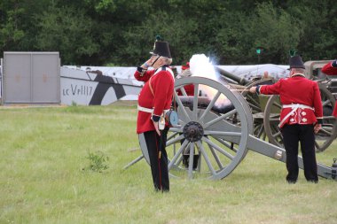 Waterlooville, İngiltere - 26 Mayıs 2019: 19. yüzyıldan kalma taklit bir topun ateşlendiğini gösteren kostüm içindeki silah ekibi.