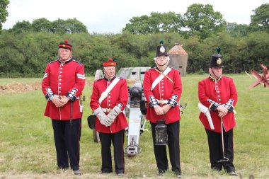 Waterlooville, İngiltere - 26 Mayıs 2019: 19. yüzyıldan kalma taklit bir topun ateşlendiğini gösteren kostüm içindeki silah ekibi.
