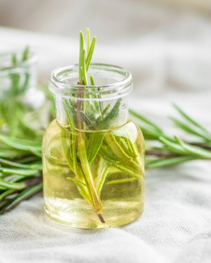 Biberiye esansiyel yağı closeup, seçici odak içinde bir taze biberiye ile küçük şişe içinde