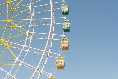 Dönme dolap bölümü mavi gökyüzü karşı yeşil ve sarı kabinleri