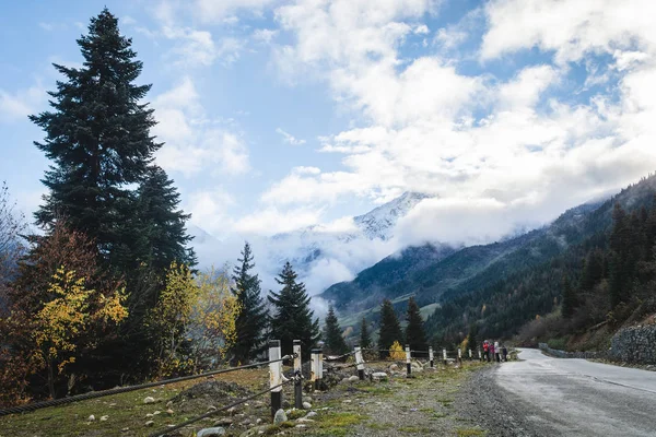 Estrada vazia nas montanhas da região de Svaneti, Geórgia. picos de neve e nuvens no fundo, paisagem de outono — Fotografia de Stock