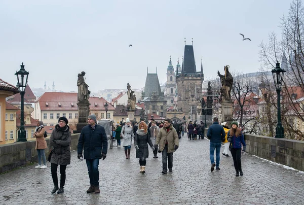 Praga, Repubblica Ceca - Dicembre 2018: i turisti passeggiano sul ponte Carlo con vista sul castello di Praga e sul fiume Moldava — Foto Stock