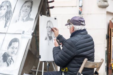 Prague, Çek Cumhuriyeti - Aralık 2018: bir portre fotoğraf Charles Köprüsü üzerinde gelen resmi bir sokak ressamın