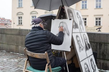 Prague, Çek Cumhuriyeti - Aralık 2018: bir portre fotoğraf Charles Köprüsü üzerinde gelen resmi bir sokak ressamın