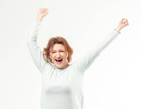 Excited adult woman with hands in the air
