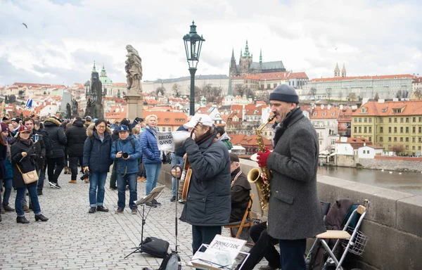 Prague, Bohemia, Çek Cumhuriyeti - Aralık 2018: ünlü Charles Köprüsü etrafında yürüyüş ve dinleme turist oynayan bir müzikal caz grubu