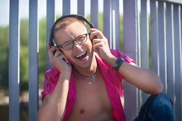 Kulaklıklar bir yaya köprüsü üzerinde yürüme pembe gömlekli Gözlüklü Şirin duygusal adam