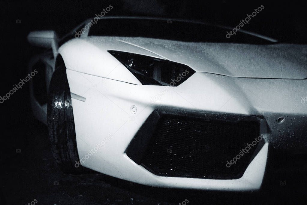 Gomel / Belarus - June 24, 2018: beautiful fast white clean with raindrops car lamborghini aventador stands outside in the garage in the evening