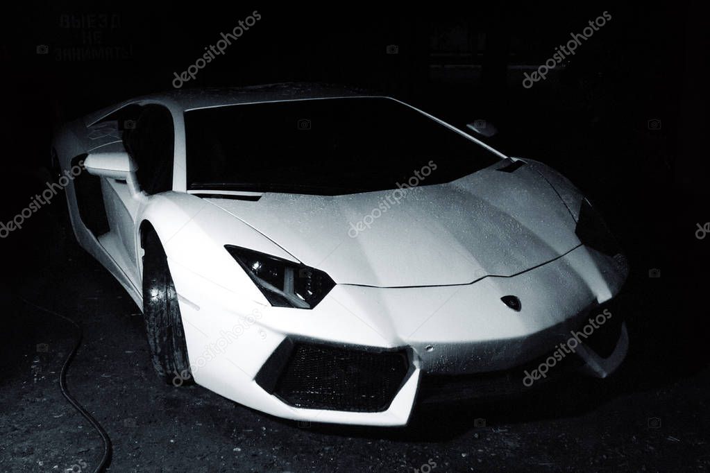 Gomel / Belarus - June 24, 2018: beautiful fast white clean with raindrops car lamborghini aventador stands outside in the garage in the evening