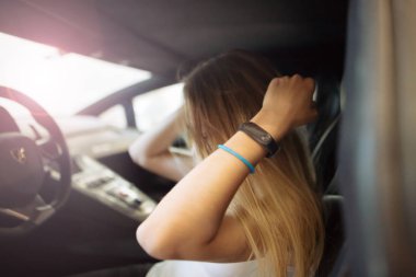 Gomel / Belarus - 1 Haziran 2018: gülümseyen, gözlüklü güzel bir kız yoldaki tozlu araba Lamborghini Aventador 'unda.