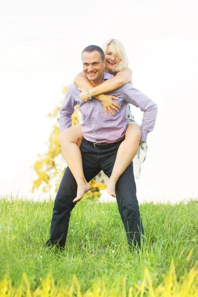 Neşeli sevgi dolu kadın ve erkek doğa üzerinde günbatımında bozulmadan