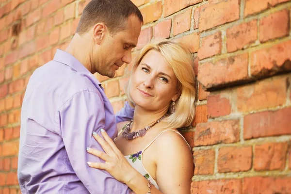 Embrace sevgi dolu kadın sarışın ve kırmızı boyalı kerber duvara bir adam Romantik Öpüşme