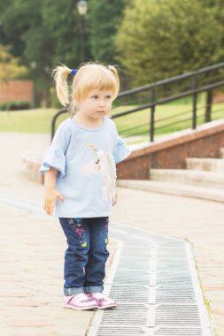 neşeli sarışın iki kuyruklu Şehir Parkı yaz güneşli havalarda sokakta boyunca yürüyüş