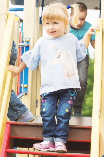 iki kuyruklu yaz güneşli havalarda Bahçesi oynamaya neşeli küçük sarışın kız