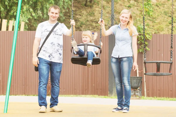 Annem ve babam ile bir küçük sarışın kız güzel bir güneşli yaz yağmur nehir kıyısında bir şehir Parkta oynayan genç çift