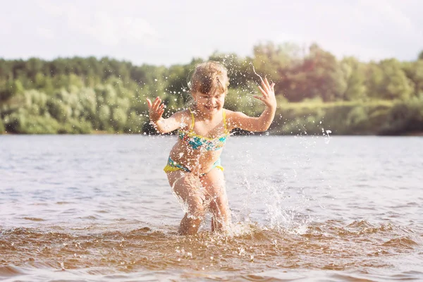 küçük sarışın bir kuyruk bir mayo ile atlama aldatarak nehre güneşli sıcak yaz havalarda kıvılcım