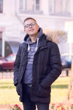 siyah ceketli siyah gözlük yakışıklı neşeli kısa insan sonbahar ve şehrin sokaklarında yürüyor