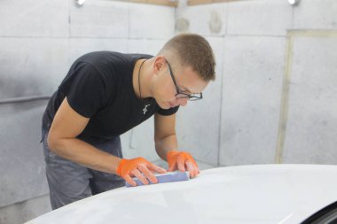 turuncu eldiven ile siyah gözlüklü şirin adam mahalle için arabanın sonraki resim şeklinde görüntüler. adam - bir ev bir araba garajda çalıştığı ressam 