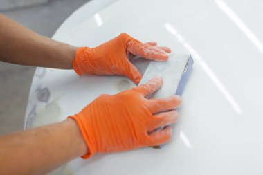 turuncu eldiven erkek elinde mahalle arabanın sonraki eipoking için biçiminde. Araba garajda çalışan adam