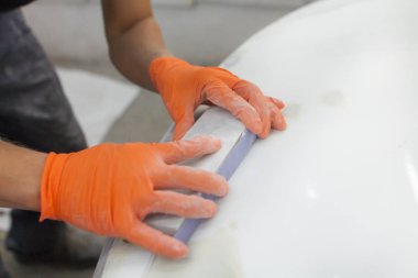 turuncu eldiven erkek elinde mahalle arabanın sonraki eipoking için biçiminde. Araba garajda çalışan adam