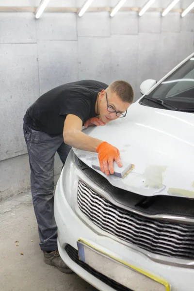 turuncu eldiven ile siyah gözlüklü şirin adam mahalle için arabanın sonraki resim şeklinde görüntüler. adam - bir ev bir araba garajda çalıştığı ressam 