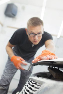 turuncu eldiven ile siyah gözlüklü şirin adam mahalle için arabanın sonraki resim şeklinde görüntüler. adam - bir ev bir araba garajda çalıştığı ressam 