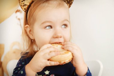 Mutlu küçük kız Noel arifesinde aşçılar, donut yiyor