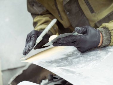 gözlük lüzifi siyah eldiven bir garajın bir araba kapağı bölümü ile sevimli adam